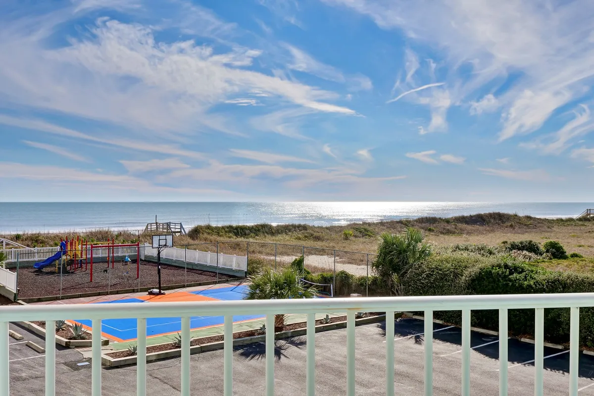 This hero image showcases a stunning, wide-open ocean view under a brilliant blue sky, with a vibrant playground and a basketball court in the foreground, all set against the inviting backdrop of North Topsail Beach. The scene evokes lively summer days, tranquil mornings, and fun-filled activities by the shore, perfectly capturing the essence of a family-friendly coastal retreat.
